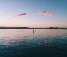 Lonely persone rowing on empty calm beach Stock Photo