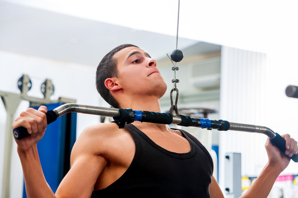 Man exercising back muscles in gym Stock Photo