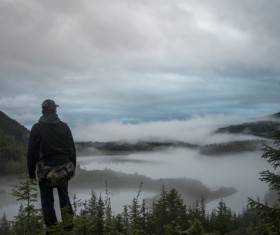 Man standing on the top of the mountain looking at the sea of clouds Stock Photo