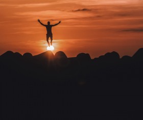 Man with artistic pose standing on sun Stock Photo