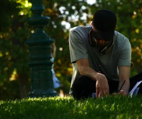 People sitting in the grass to write things Stock Photo