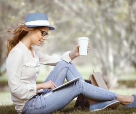 Sitting on the grass relaxing girl using laptop Stock Photo