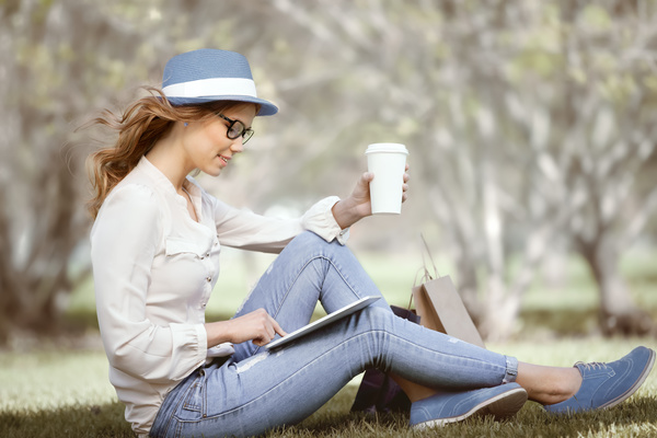Sitting on the grass relaxing girl using laptop Stock Photo