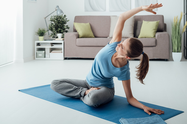 Slim Woman Practicing Yoga On A Mat Indoors Doing Pilates