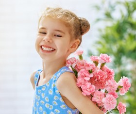 Smiling little girl holding flowers Stock Photo