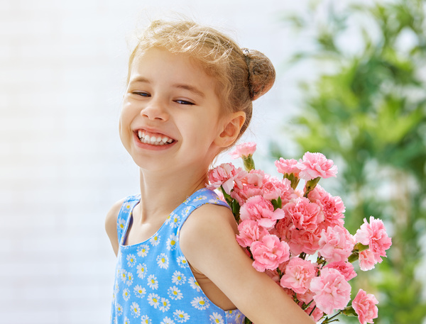 Smiling little girl holding flowers Stock Photo