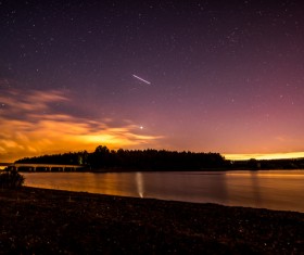 Starry sky above serene lake landscape Stock Photo