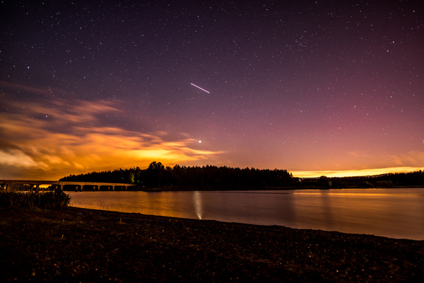 Starry sky above serene lake landscape Stock Photo