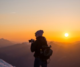 Tourist enjoying frozen mountain scene at dusk Stock Photo