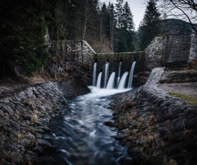 Waterfall on stone dike Stock Photo