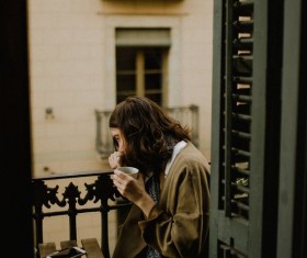 Woman drinking coffee on balcony Stock Photo