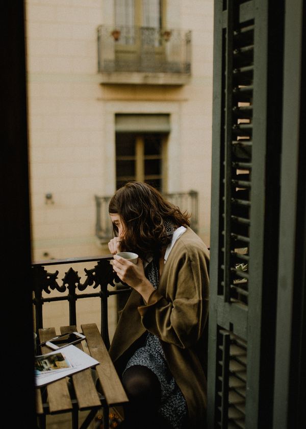 Woman drinking coffee on balcony Stock Photo