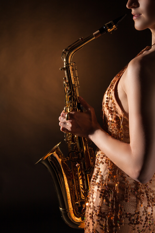 Woman holding blowing saxophone Stock Photo