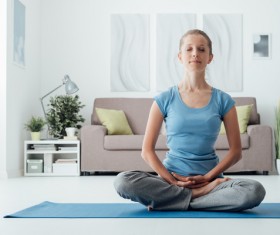 Woman sitting meditation indoors Stock Photo