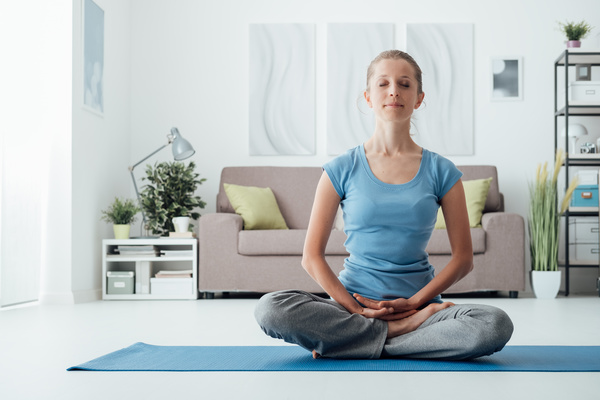 Woman sitting meditation indoors Stock Photo