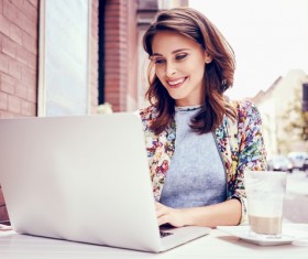 Woman using laptop in open-air coffee house Stock Photo 01