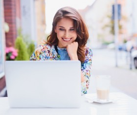 Woman using laptop in open-air coffee house Stock Photo 02