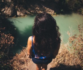 Young girl watching peaceful lake scene from height Stock Photo