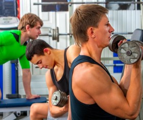 Young man doing arm exercise in gym Stock Photo