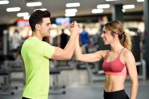 Young men and women shaking hands in gym Stock Photo