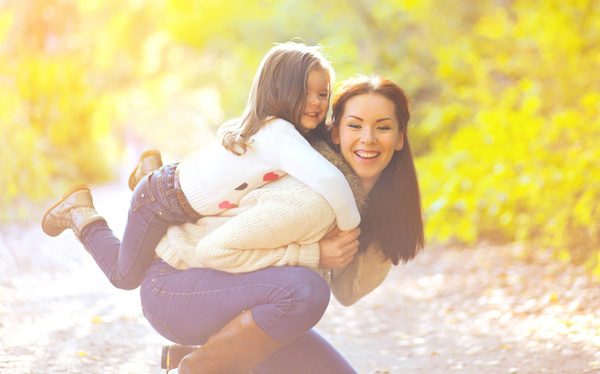 Young mother carrying daughter Stock Photo