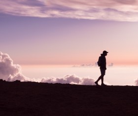 backpacker walking on mountain scene Stock Photo