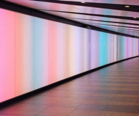 person walking in empty shiny colorful tunnel Stock Photo