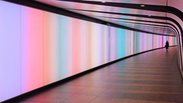 person walking in empty shiny colorful tunnel Stock Photo