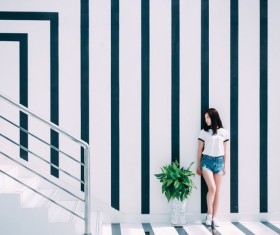 Attractive young girl posing near stripes wall Stock Photo