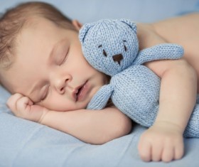 Baby holding knitted bear sleeping Stock Photo 01