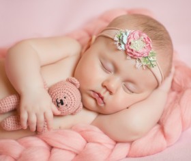Baby holding knitted bear sleeping Stock Photo 02