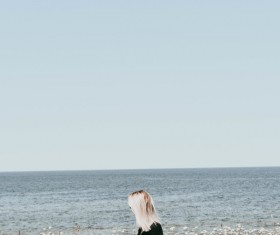 Blonde girl walks among wild flowers Stock Photo
