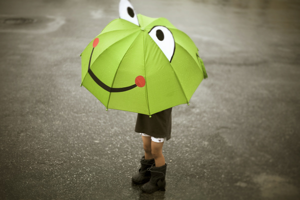 Child playing cartoon frog umbrella Stock Photo