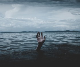 Drowning man waving hands Stock Photo