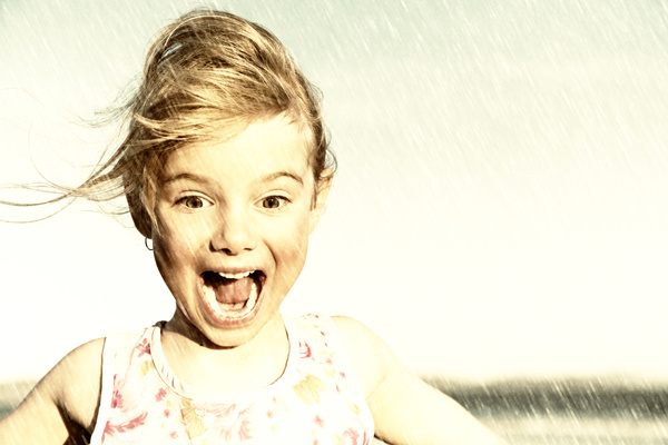 Excited little girl in the rain Stock Photo