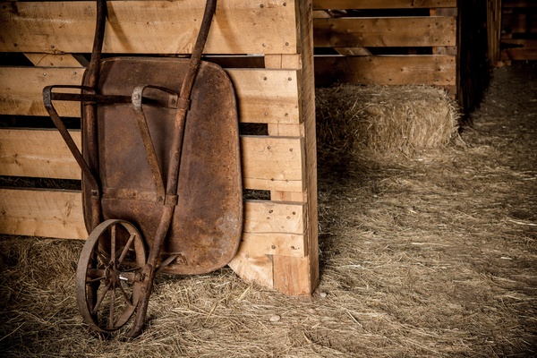 Farmhouse rusty wheelbarrow Stock Photo