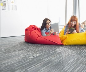 Girl playing Tablet PC in inflatable chair Stock Photo 01
