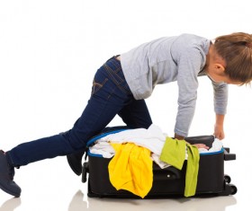 Little girl arranging suitcase clothes Stock Photo