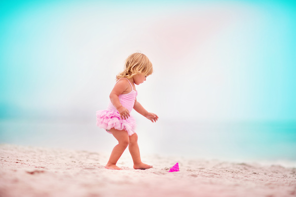 Little girl playing on the beach Stock Photo