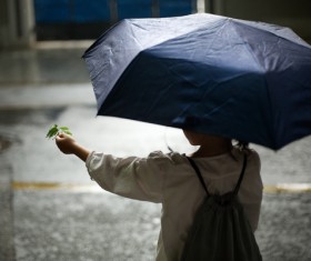 Little girl playing outdoors on rainy day Stock Photo 02