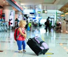 Little girl pulling luggage at the station Stock Photo