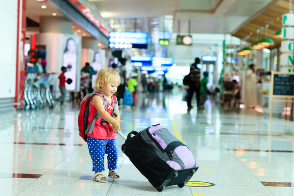 Little girl pulling luggage at the station Stock Photo
