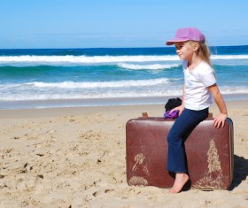 Little girl sitting on suitcase Stock Photo