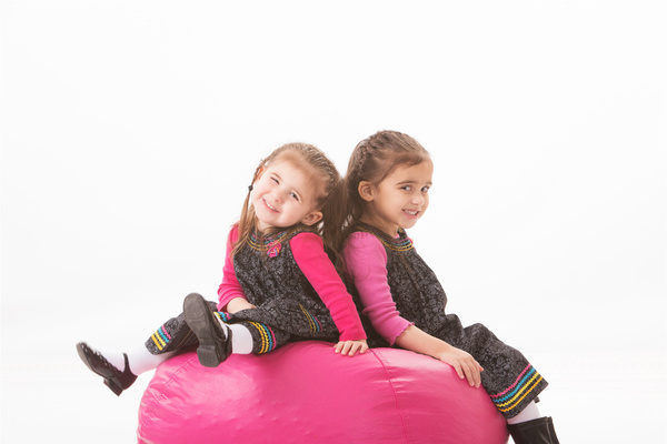 Little sisters sitting in inflatable chair Stock Photo