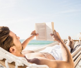 Man lying in hammock reading Stock Photo 02