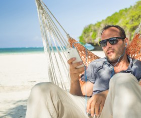 Man relaxing in hammock listening to music Stock Photo