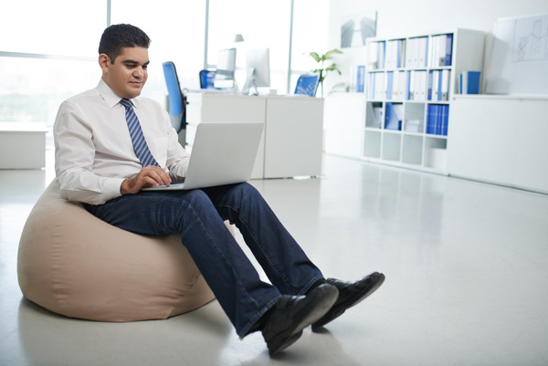 Man sitting in inflatable chair surfing the internet Stock Photo