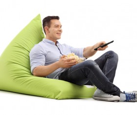 Man sitting in inflatable chair watching TV Stock Photo