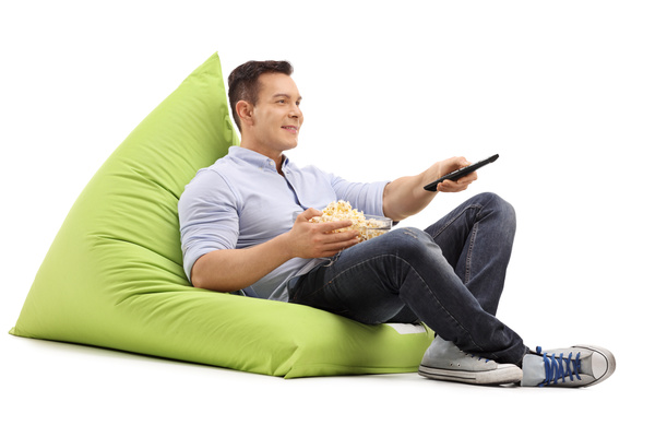 Man sitting in inflatable chair watching TV Stock Photo