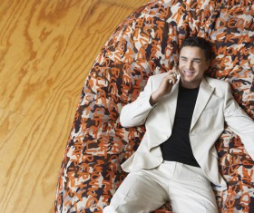 Man sitting on inflatable chair and phoning Stock Photo